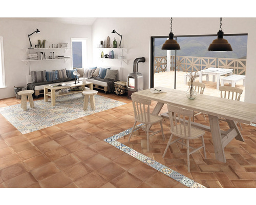 Wohnraum mit Terrakottafliesen, Holztisch, Sitzgelegenheiten und dekorativem Kamin