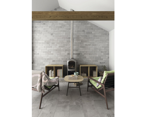 Wohnzimmer mit Kaminofen, Backsteinwand und Holzbalken