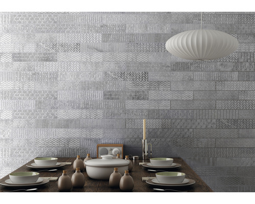 Esszimmer mit silberfarbenen Wandfliesen und gedecktem Holztisch