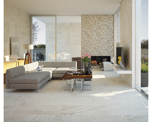 Heller Wohnraum mit Fliesenboden, Couch und Kamin.