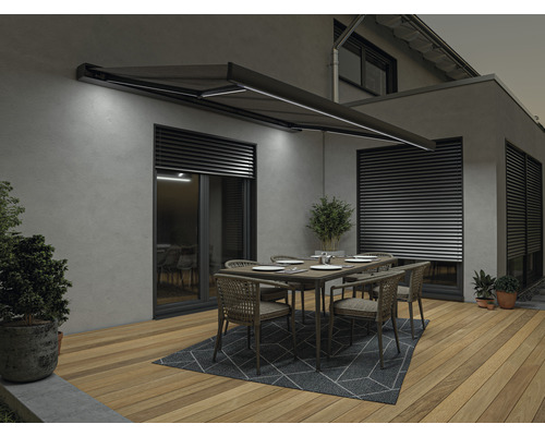 Terrasse mit Markise, Tisch und Stühlen vor einem Haus