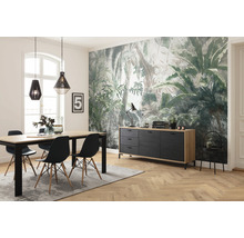 Esszimmer mit Esstisch, Stühlen, Sideboard und Deko vor einer Dschungeltapete.