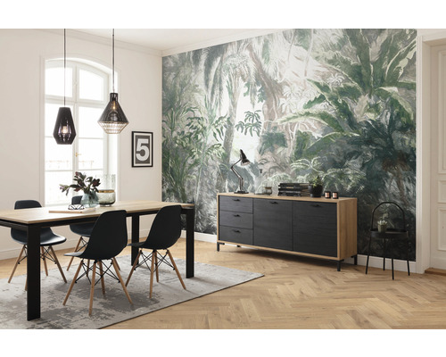 Esszimmer mit Esstisch, Stühlen, Sideboard und Deko vor einer Dschungeltapete.