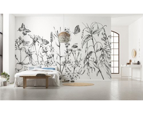 Geräumiges Schlafzimmer mit floraler Fototapete, Bett und Flechtlampe