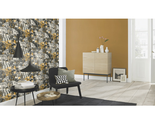 Wohnzimmer mit gemusterter Tapete, Sessel und Beistelltischen.