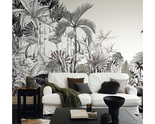 Wohnzimmer mit Fototapete mit Dschungelmotiv, weißem Sofa und schwarzen Möbeln.