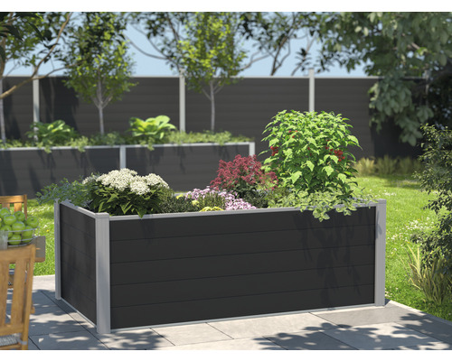 Hochbeet aus Kunststoff mit verschiedenen Pflanzen in einem Garten.