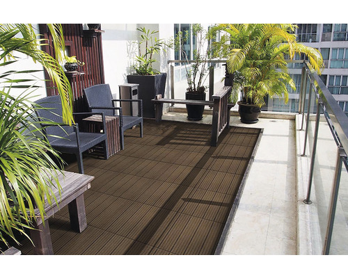 Terrasse mit braunen Terrassenfliesen, Sitzmöbeln und Pflanzen.