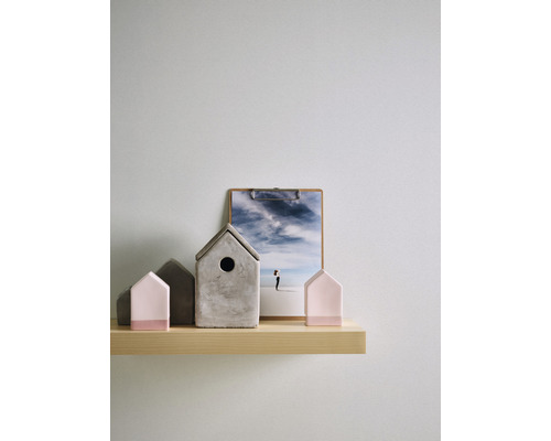 Dekorative Häuser aus Beton und eine Fotografie auf einem Holzregal