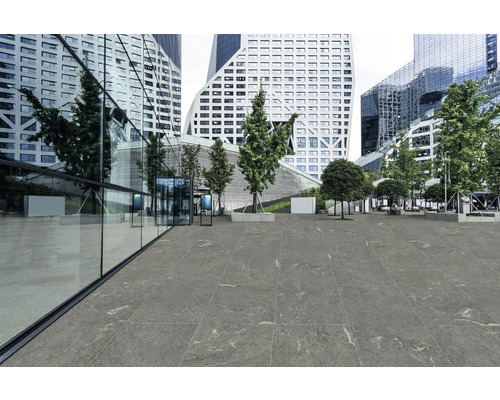 Außenbereich mit Bodenfliesen vor modernen Bürogebäuden und Bäumen