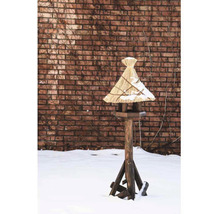 Vogelhaus aus Holz mit Strohdach im verschneiten Garten