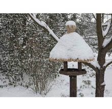 Vogelhaus mit Schnee im winterlichen Garten