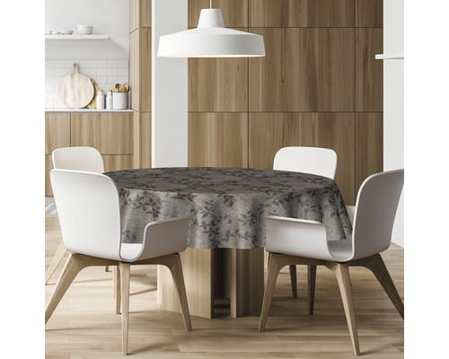 Runder Esstisch mit gemusterter Tischdecke und vier Stühlen in einer Küche.