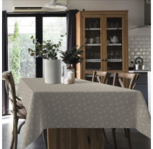 Esstisch mit gemusterter Tischdecke, Blumenvasen und Stühlen in einem hellen Raum.