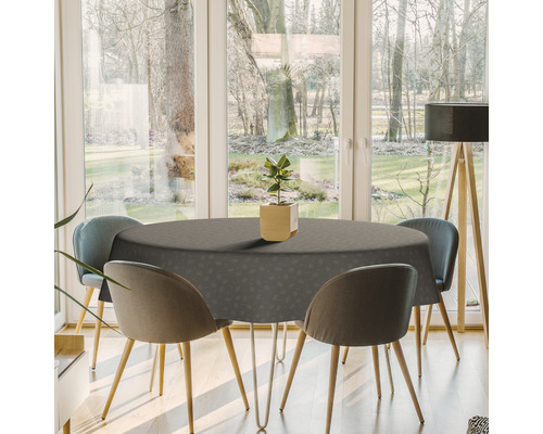 Esstisch mit grauer Tischdecke und Stühlen in einem hellen Raum