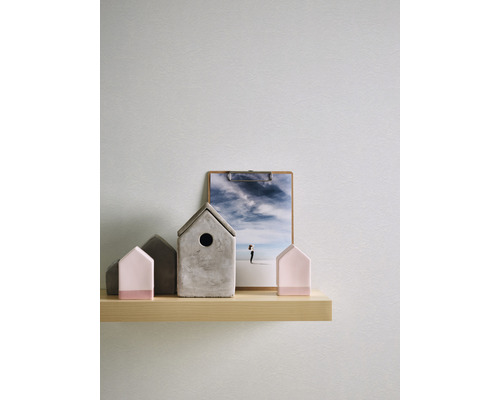 Dekorative Häuser und ein Klemmbrett auf einem Regal
