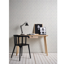 Schreibtisch mit Stuhl, Lampe und Dekoration in einem hellen Raum