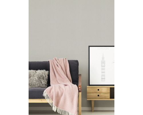 Wohnzimmer mit Sofa, Kissen, Decke und Kommode mit Bild