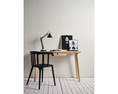 Schreibtisch mit Lampe, Stuhl und Deko-Elementen in einem hellen Raum