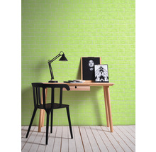 Ein Arbeitszimmer mit einem Schreibtisch, einem Stuhl und einer Lampe vor einer Wand mit Ziegelmuster