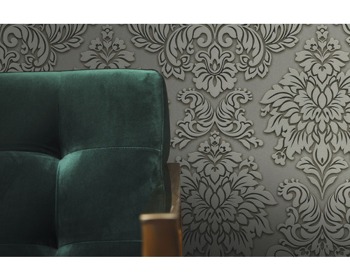 Nahaufnahme von einer gepolsterten Couch vor einer floral gemusterten Tapete