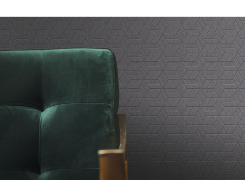 Gemusterte Tapete mit geometrischen Formen und dunkelgrünes Sofa