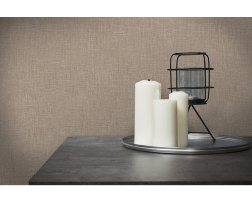 Nahaufnahme einer Wand mit Textiltapete, kombiniert mit Kerzen und Windlicht