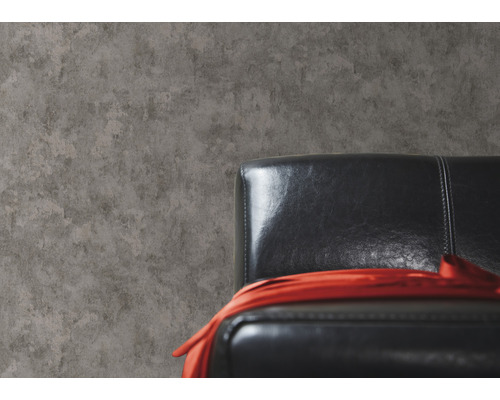 Tapete in Betonoptik neben einem schwarzen Ledersessel