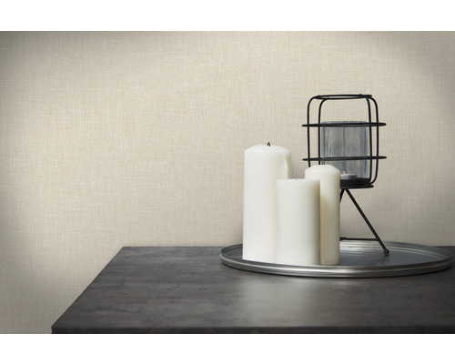 Dekorative Tapete mit Leinenstruktur, kombiniert mit Kerzen und Windlicht auf einem Tisch.