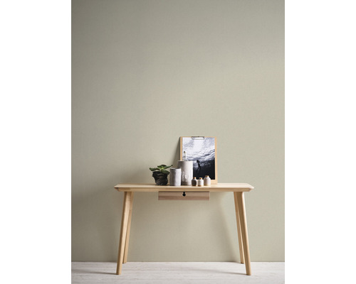 Helles Holzschreibtisch mit Schublade, Dekoration und Bild an der Wand.