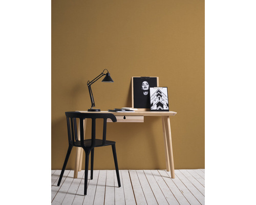 Schreibtisch mit Lampe, Stuhl und Dekoration im Zimmer
