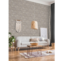 Wohnzimmer mit gemusterter Tapete, Sofa, Tisch und dekorativen Elementen für eine gemütliche Atmosphäre
