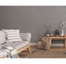 Wohnraum mit grauer Strukturtapete, Sofa, Tisch und Dekoration