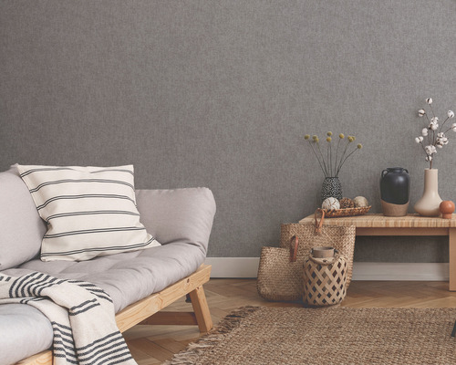 Wohnraum mit grauer Strukturtapete, Sofa, Tisch und Dekoration