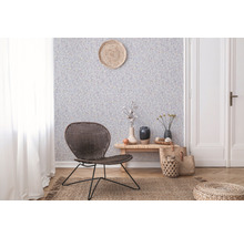 Wohnraum mit gemusterter Tapete, Rattansessel und Holzboden