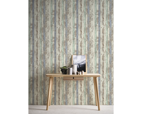 Dekorative Wand mit Tapete in Holzoptik und hellem Holztisch