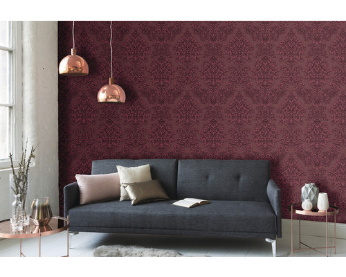 Wohnzimmer mit grauer Couch, gemusterter Tapete und Pendelleuchten