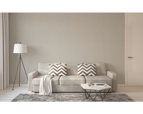 Wohnzimmer mit Sofa, Kissen, Teppich, Stehlampe und Tisch