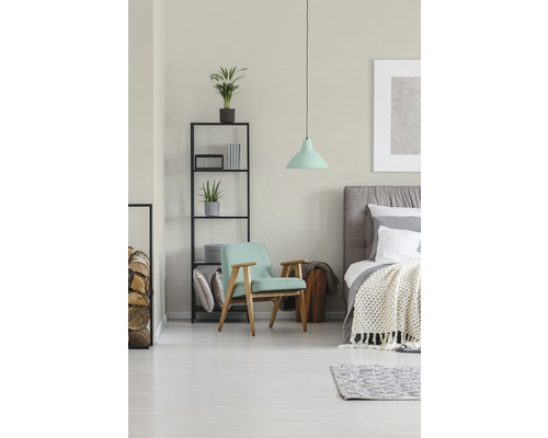Helles Schlafzimmer mit Sessel, Bett und Regal