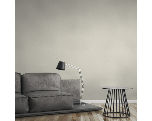 Ein Wohnzimmer mit grauer Couch, Stehlampe und kleinem Beistelltisch.