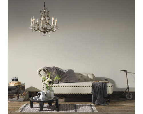 Wohnzimmer mit Kristalllüster, Bank, Tisch und Dekorationsgegenständen