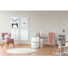 Kinderzimmer mit Kinderbett, Sessel, Kommode, Bildern und Spielzeug