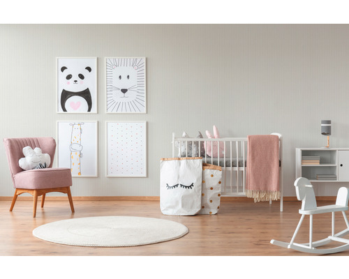 Kinderzimmer mit Kinderbett, Sessel, Kommode, Bildern und Spielzeug
