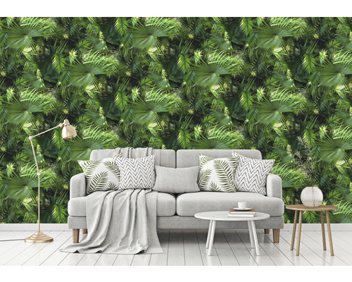 Wohnzimmer mit Couch vor einer Tapete mit Palmenmuster