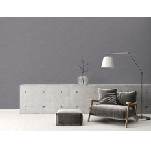 Wohnraum mit grauer Wand, Sessel, Lampe und Dekor