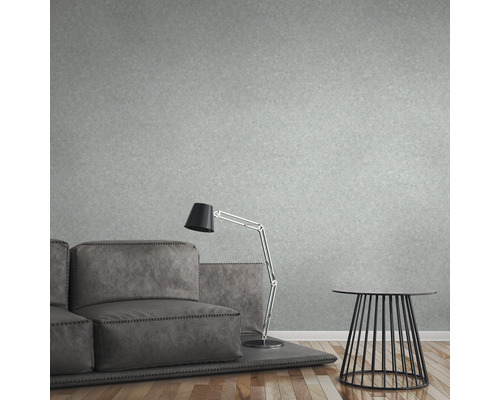 Wohnzimmer mit grauer Couch, Stehlampe und Beistelltisch vor einer strukturierten Tapete