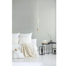 Hell eingerichtetes Schlafzimmer mit Bett, Beistelltischen und Lampe