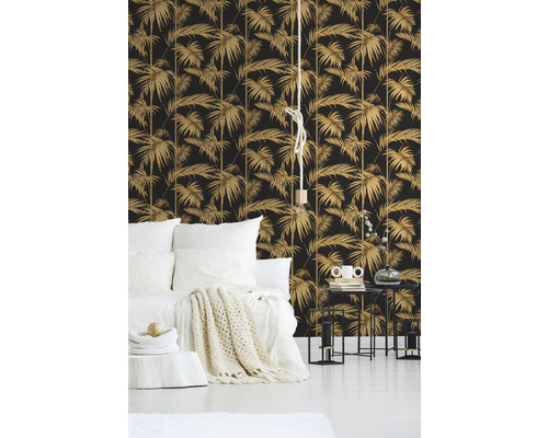 Schlafzimmer mit Bett, Nachttischen und Tapete mit Palmenmuster