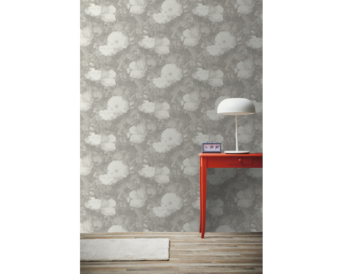 Innenraum mit Blumentapete, rotem Tisch, Lampe und Teppich