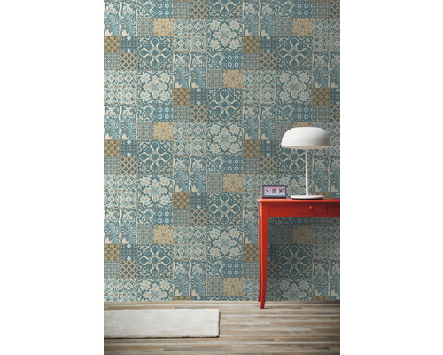 Zimmeransicht mit gemusterter Tapete, rotem Tisch und Lampe